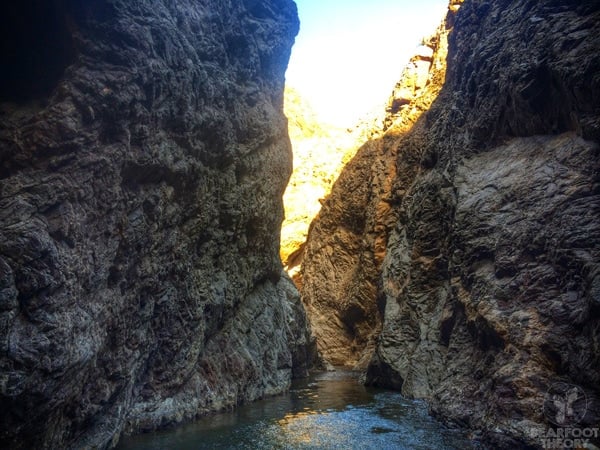 Pool of water between two tall rock walls in Boy Scout Canyon in Nevada