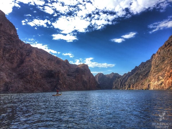 Paddleboarder kneeling on board on the Black Canyon Water Trail in Nevada