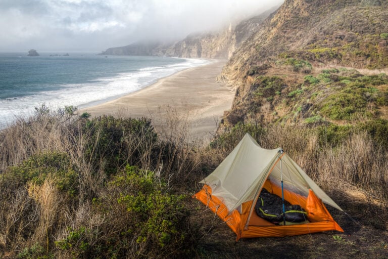 Tent set up at campsite overlooking rugged beach in Point Reyes, California