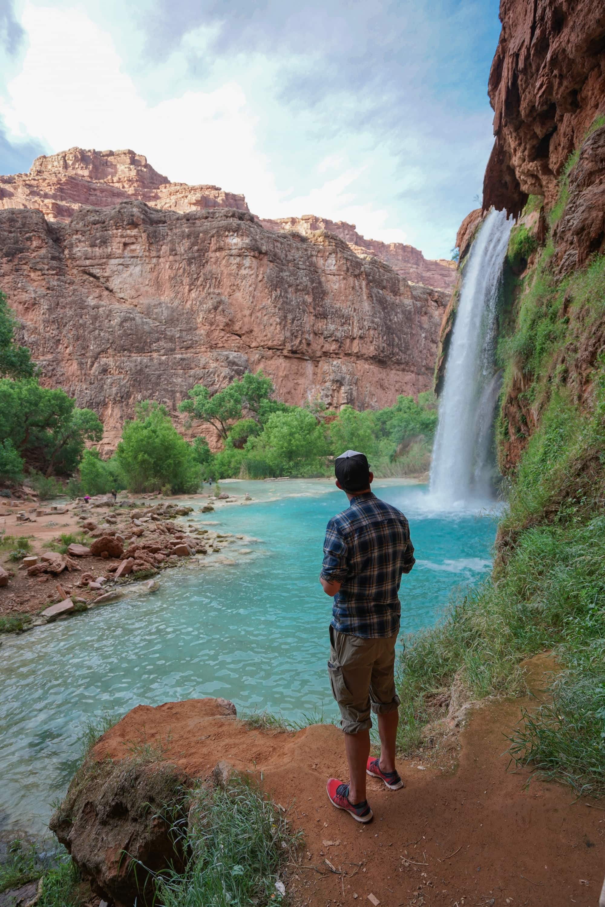 Man standing at base of Havasu Falls