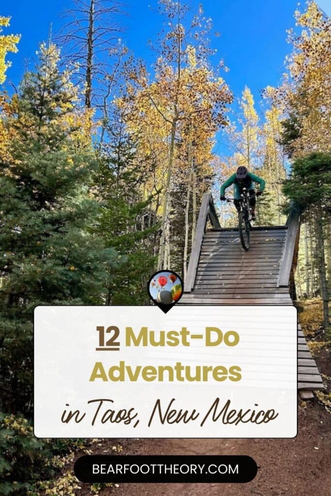 Mountain biker riding off wooden ramp next to golden aspen trees. Text reads "12 must-do adventures in Taos, New Mexico"