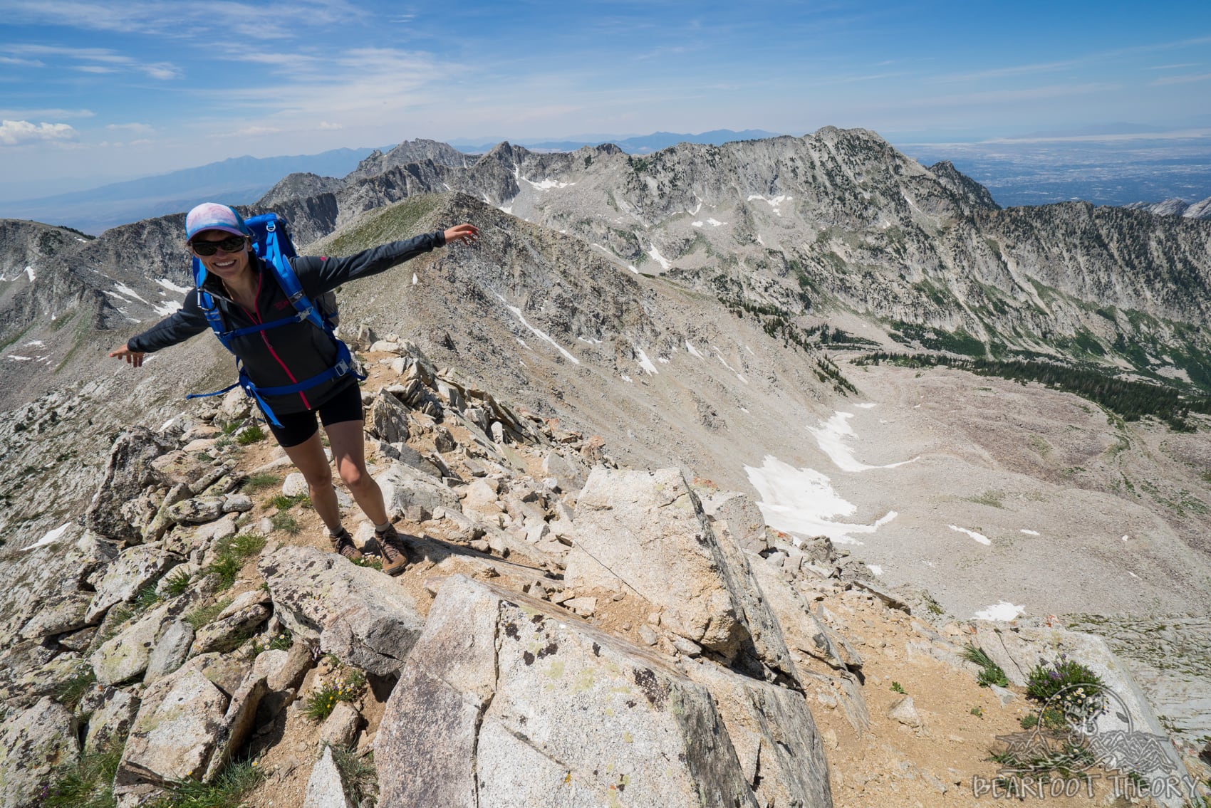 Woman with her arms outstretched on the summit of the Pfeifferhorn, the third tallest peak near Salt Lake City in the Wasatch Mountain Range