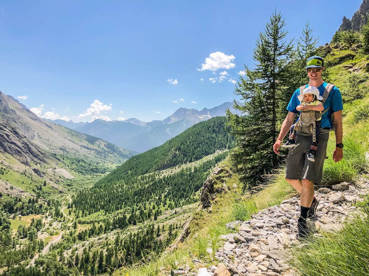 Man hiking on trail in the Italian Alps with baby strapped to chest