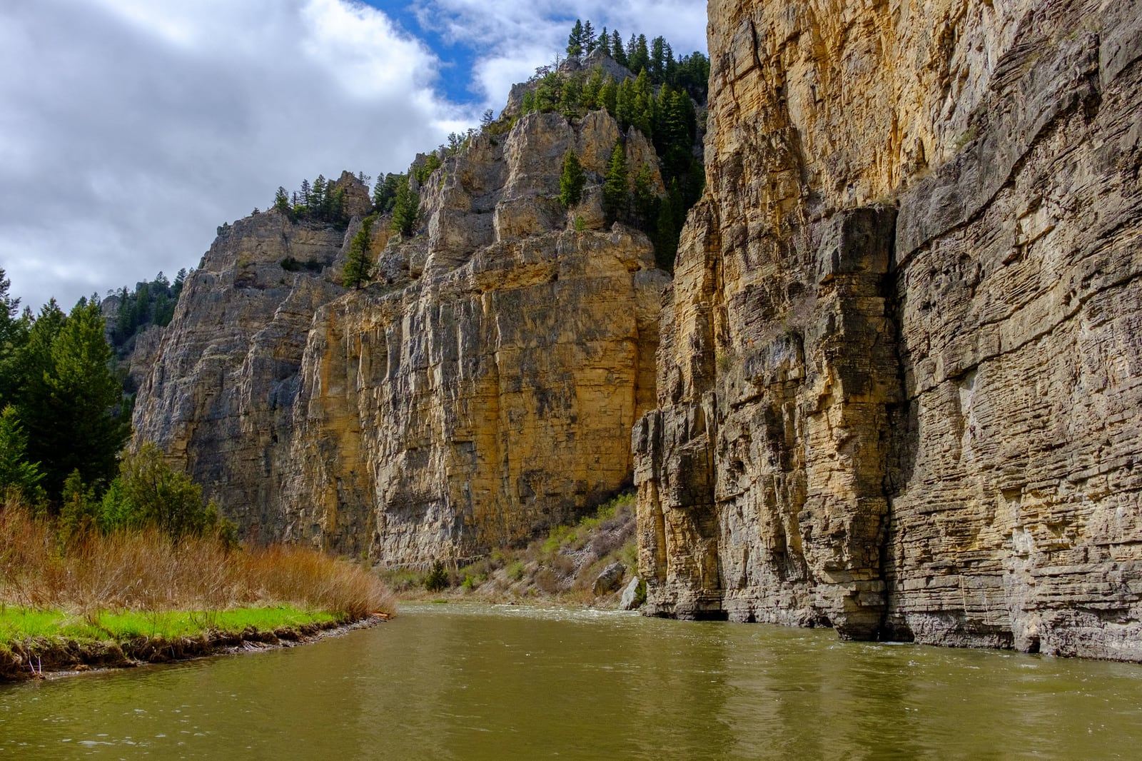 Smith River with tall rock cliffs on right side of river