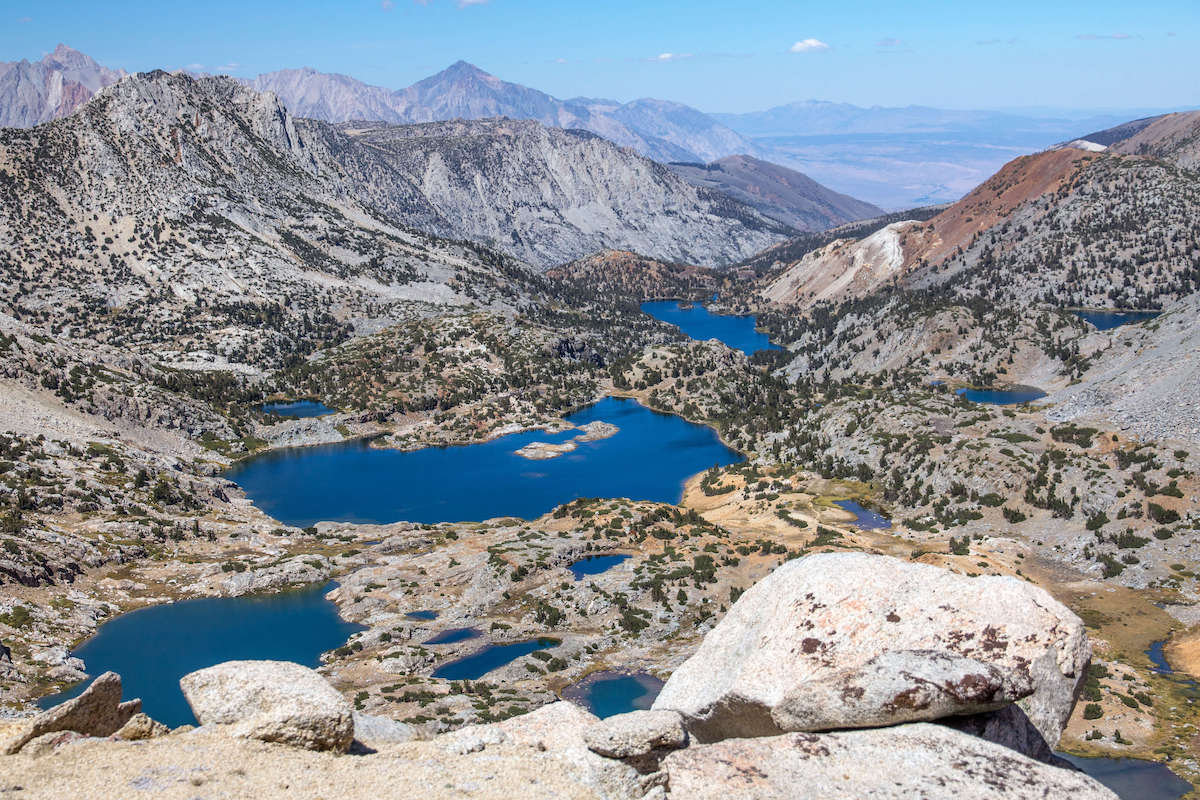 Scenic landscape photo out over a lakes basin from Bishop Pass Trail in the Eastern Sierra of California