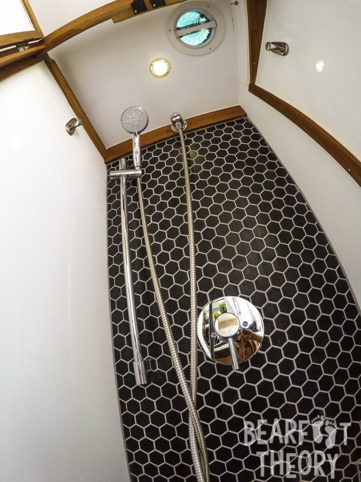 Interior of the floor to cieling custom bathroom showing the shower and tiles in Kristen's first Mercedes sprinter camper van