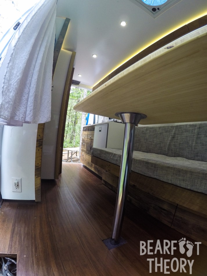 Interior photo of my first Mercedes Sprinter camper van showing the removable table in front of the convertible sofar bed