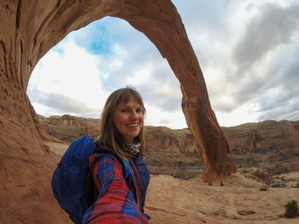 Woman taking a selfie under Corona Arch in Moab