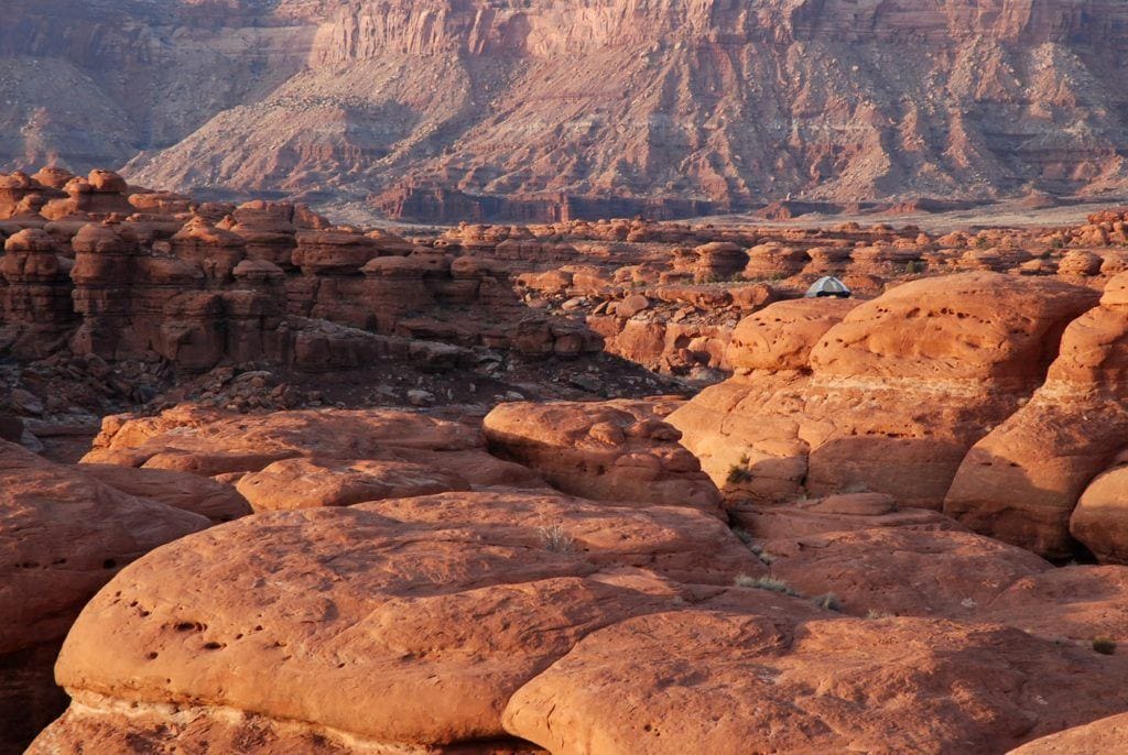 Tent set up on red rock slickrock in Canyonlands National Park in Utah