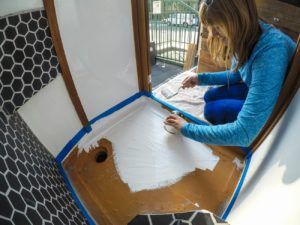 A woman installs a shower in her camper van