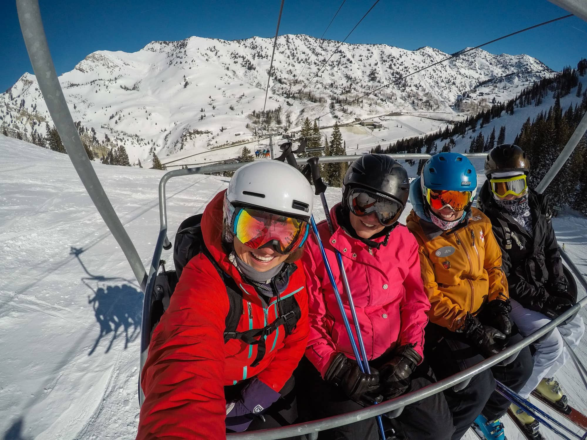 Four female skiers sit on a chair lift at Alta in Salt Lake City Utah