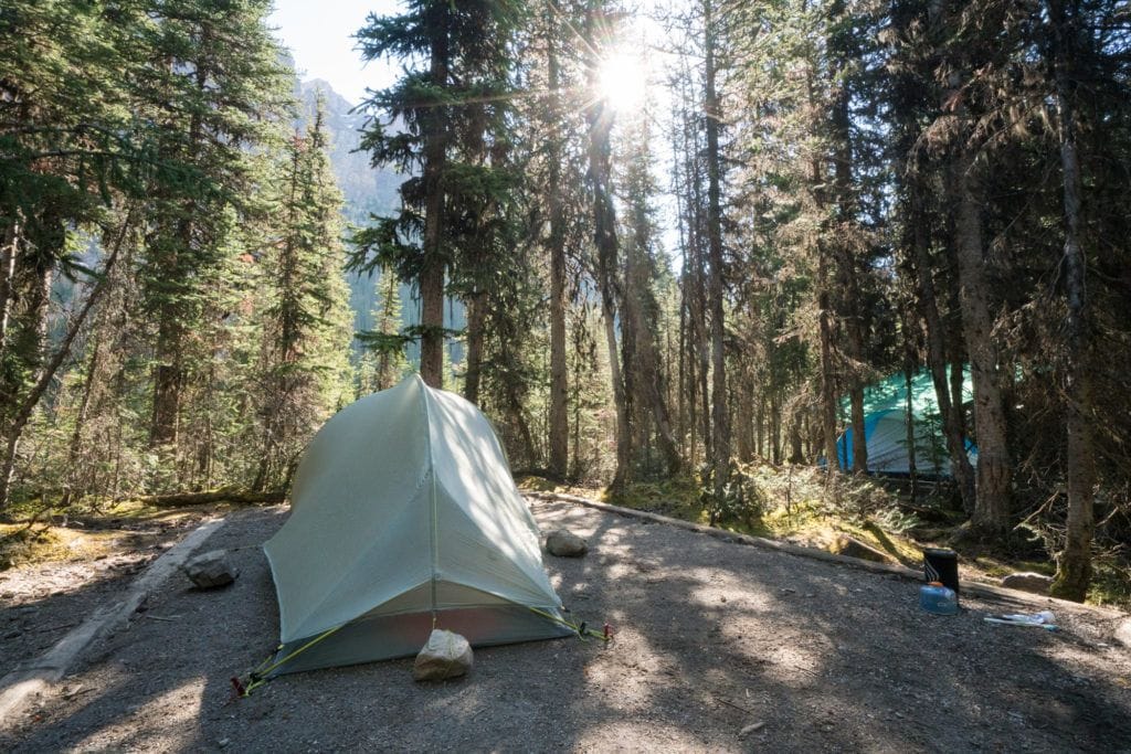 Camping tent set up on a flat gravel area at Lake O'Hara Campground in Yoho National Park in British Columbia