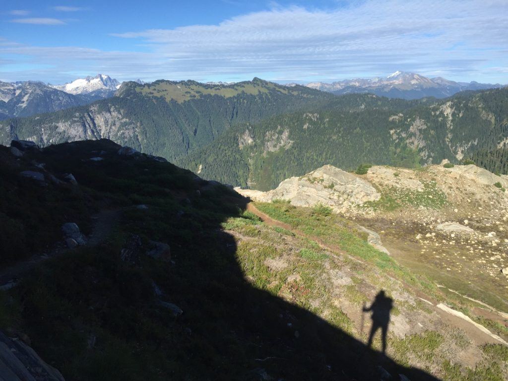 Shadow of hiker on the Pacific Crest Trail looking out into mountainous wilderness 