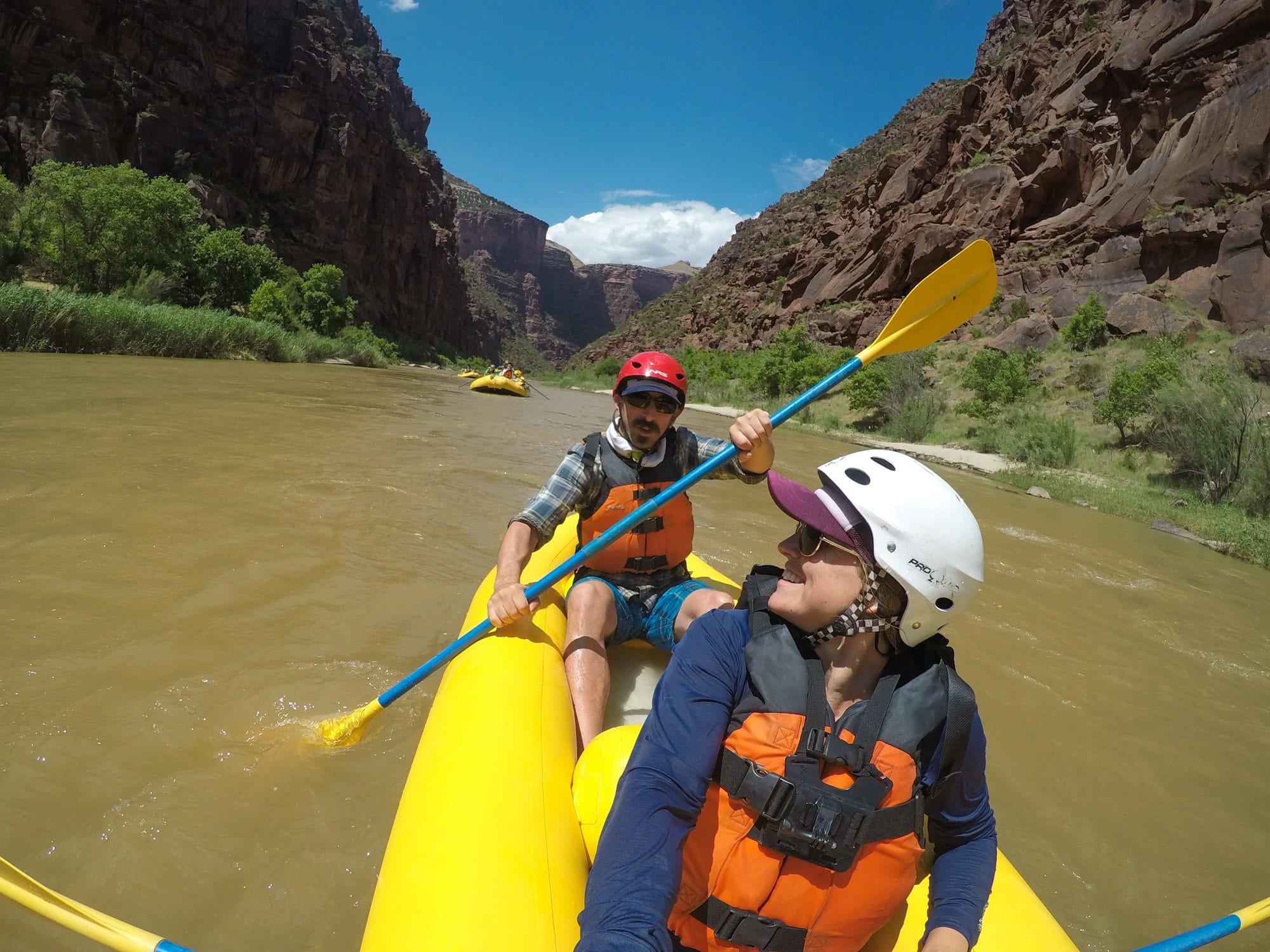 A woman and man sit in a boat rafting Gates of Lodore