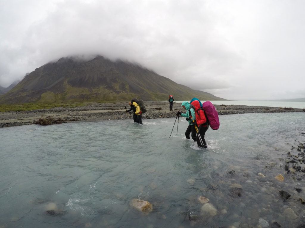 Crossing a river on a backpacking trip in lake Clark national park
