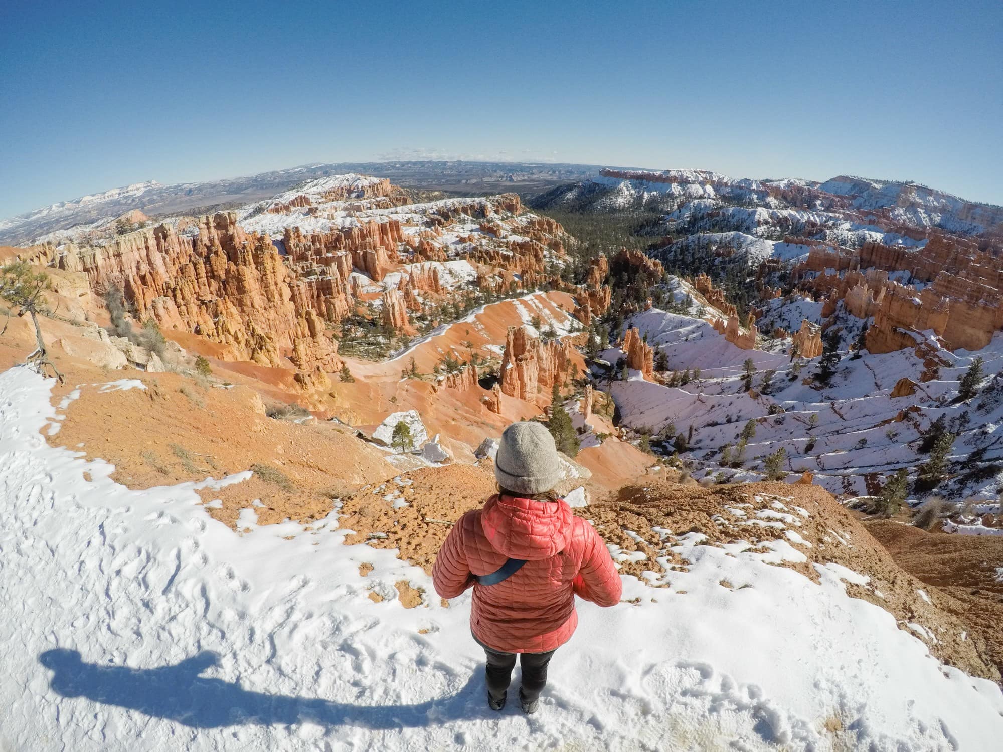 Woman looking out over snow-dusted hoodoos in Bryce Pass National Park