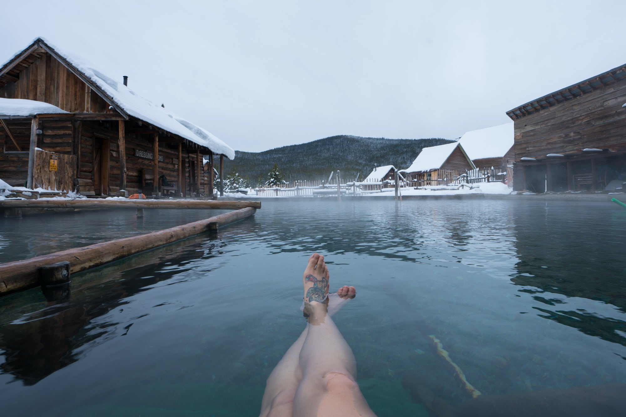 Photo of woman's legs in hot springs pool at resort in Idaho in the winter