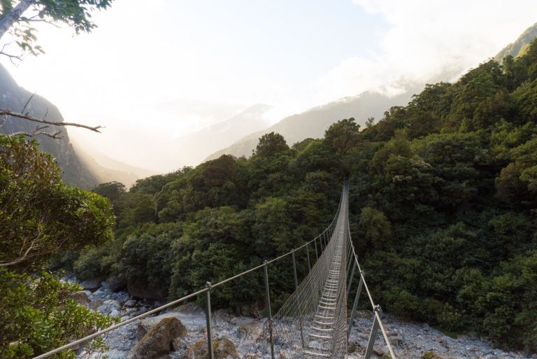 Suspension bridge over a rocky riverbed on the Copland Track in New Zealand