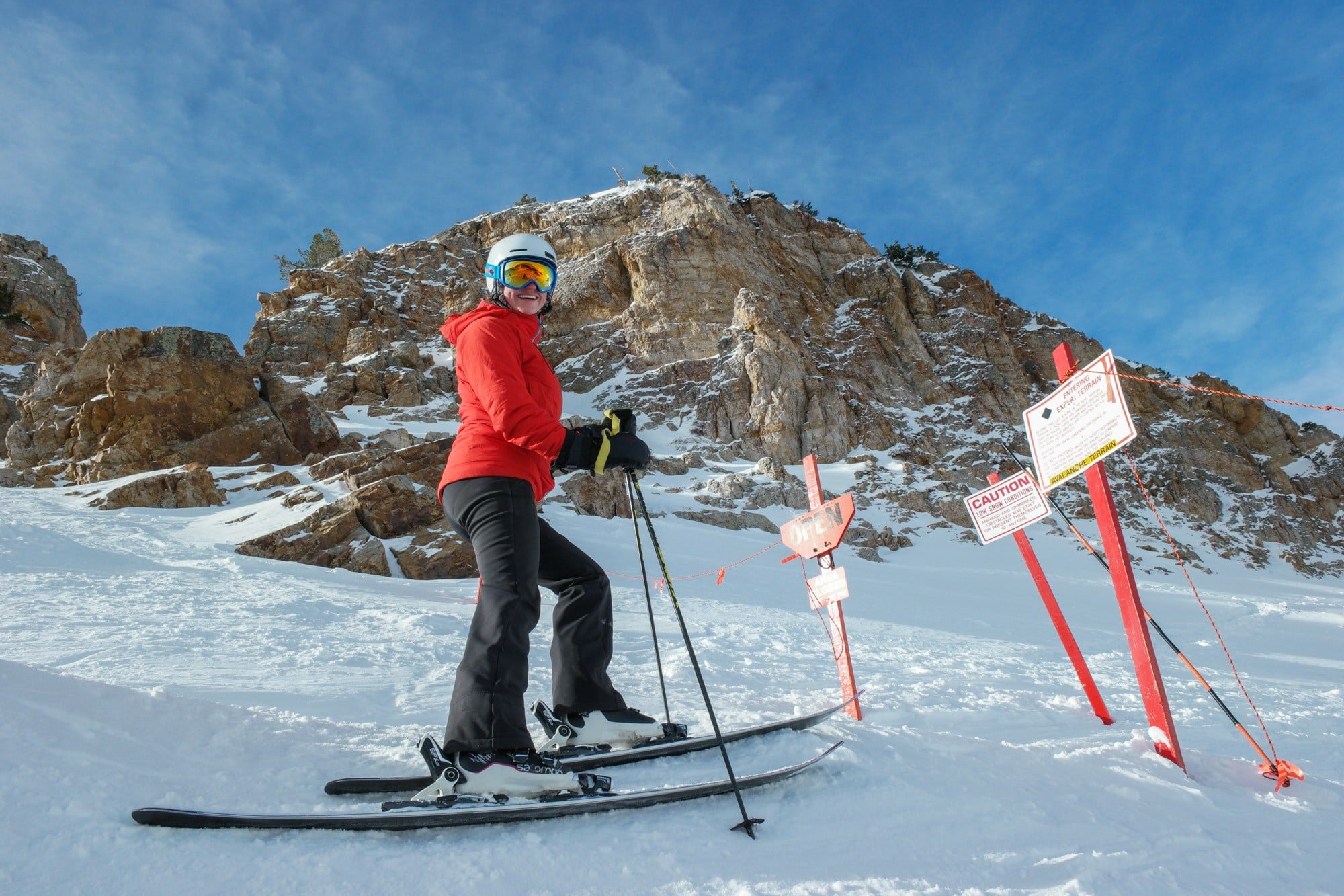 Beginner woman skier stopped at the top of a ski run