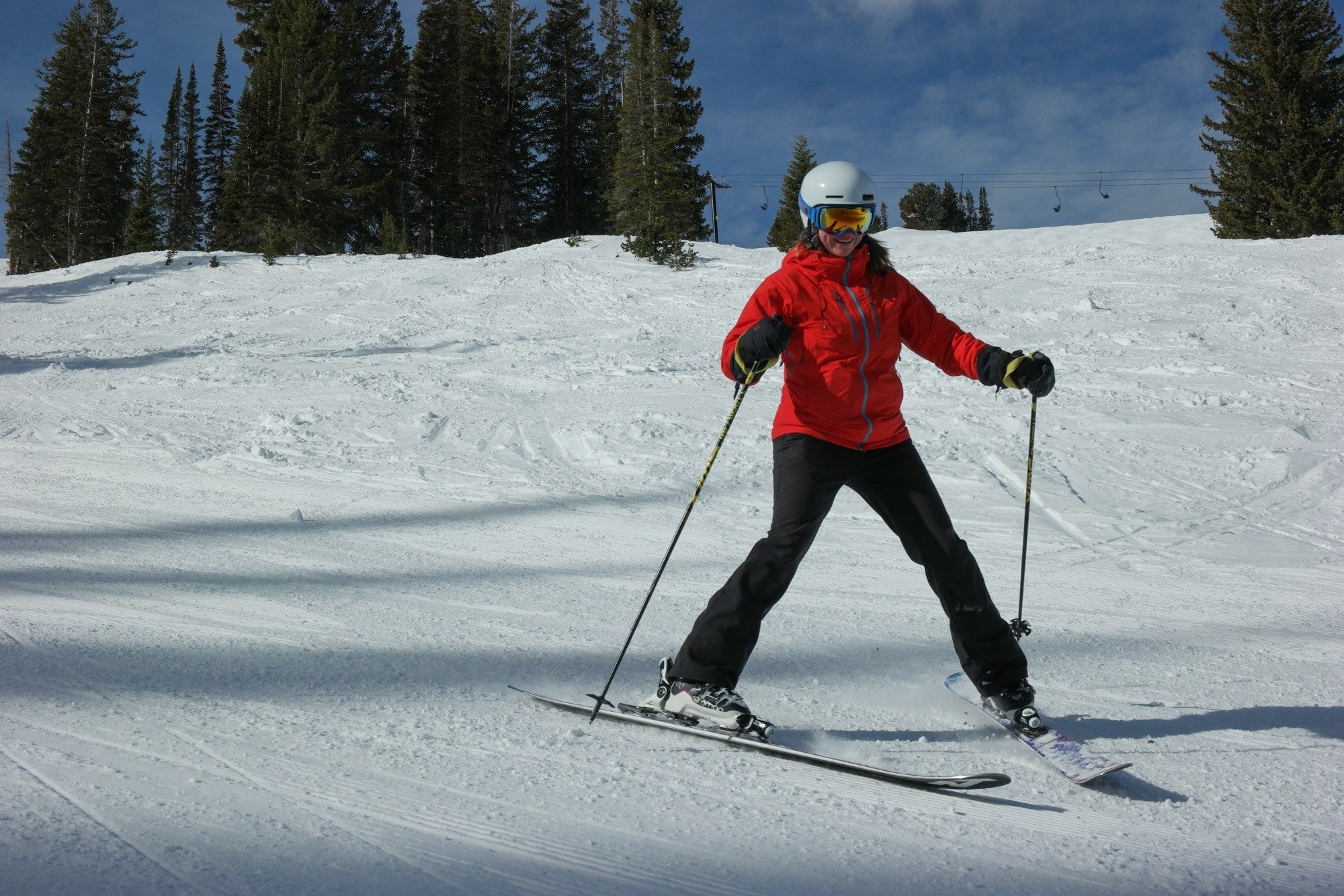 Woman skiing down groomed slope with skies in pizza formation