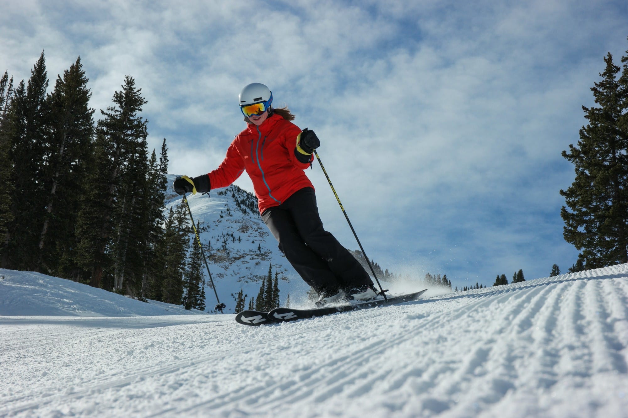 woman skiing down a mountain in a red jacket