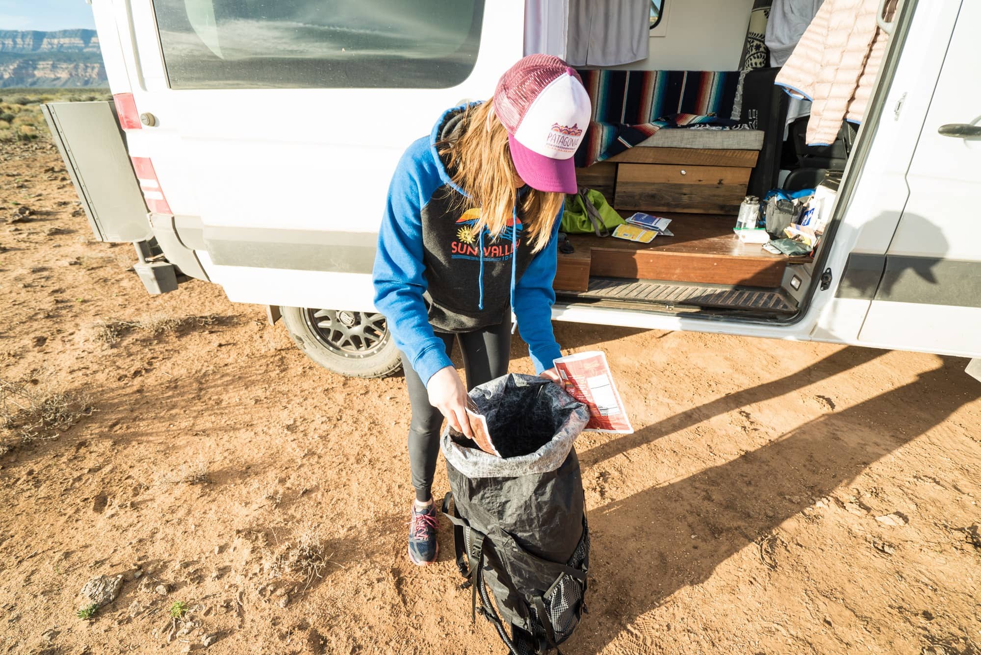 Kristen packing dehydrated meals into backpacking backpack