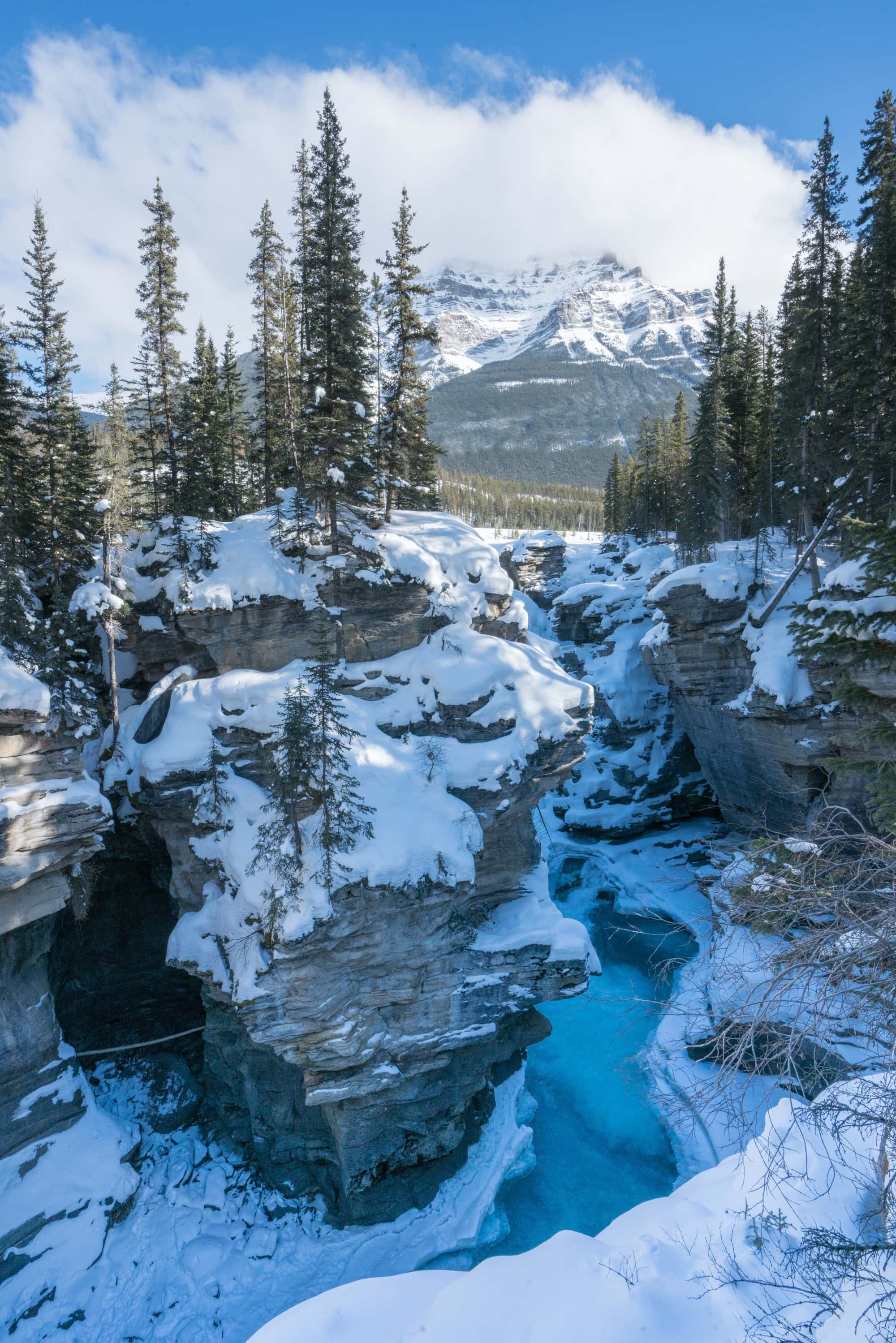 Athabasca Falls in winter // Plan your getaway to Jasper National Park in winter with our guide to the best winter activities such as skiing, dogsledding, and more.