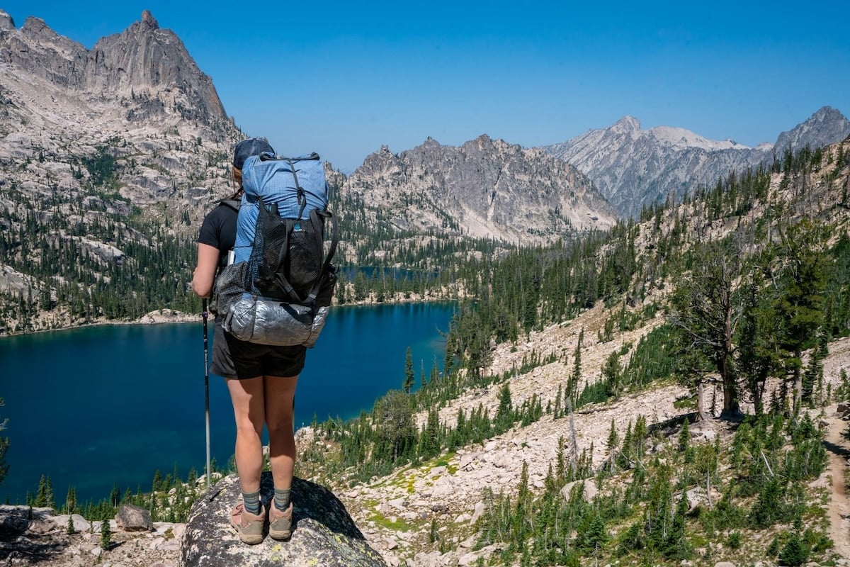 Kristen Bor with a backpacking pack in looking out over Baron Lakes in Idaho's Sawtooth Mountains