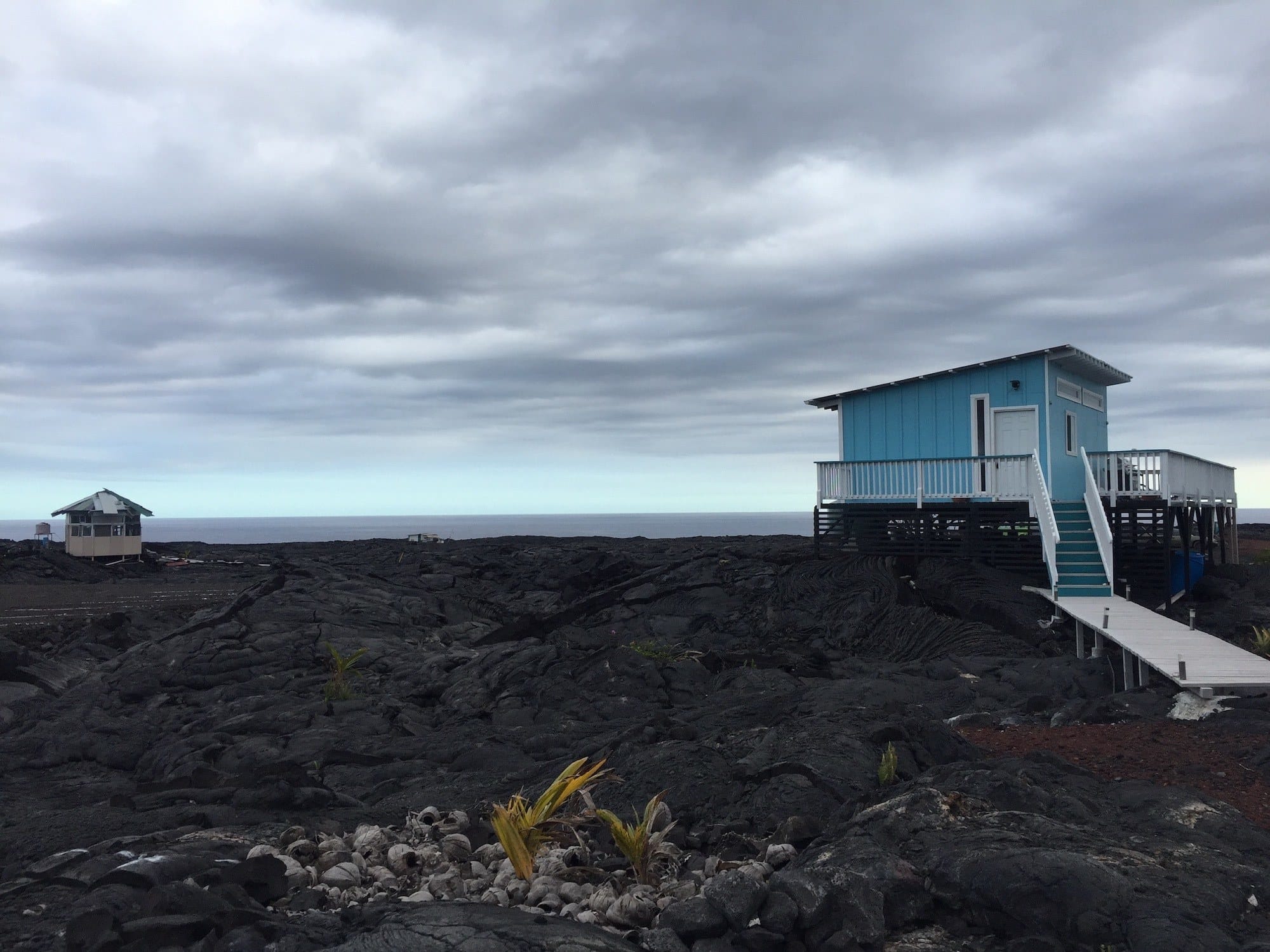 Cold lava field with small beach house structure at Kalapan in Hawaii