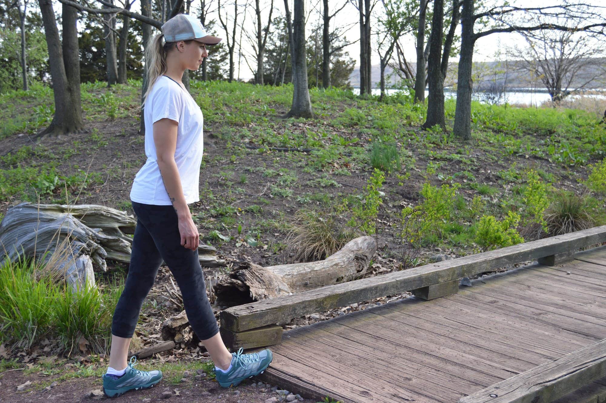 A woman does calf stretches while hiking