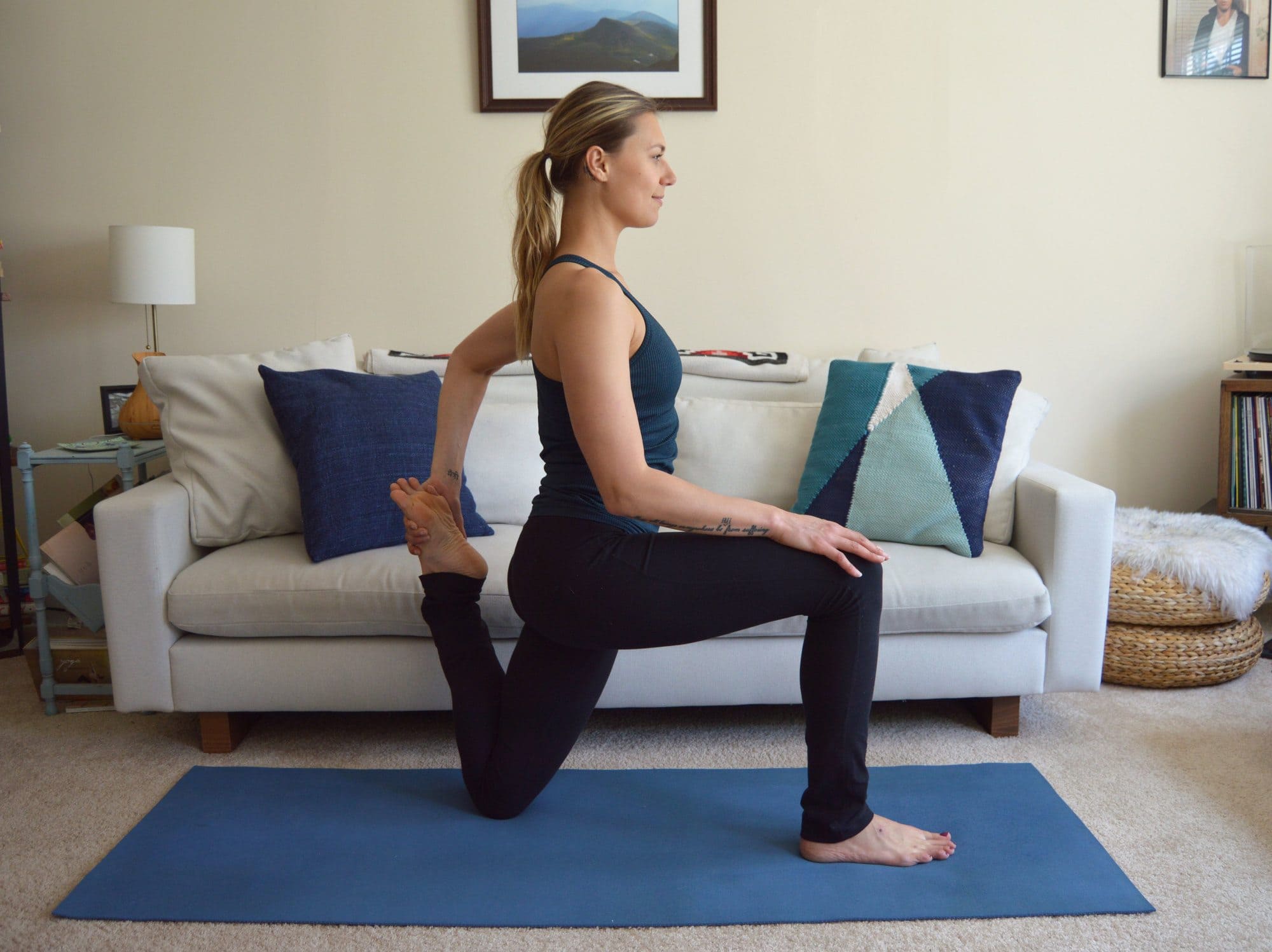 A woman does a low lunge thigh stretch at home