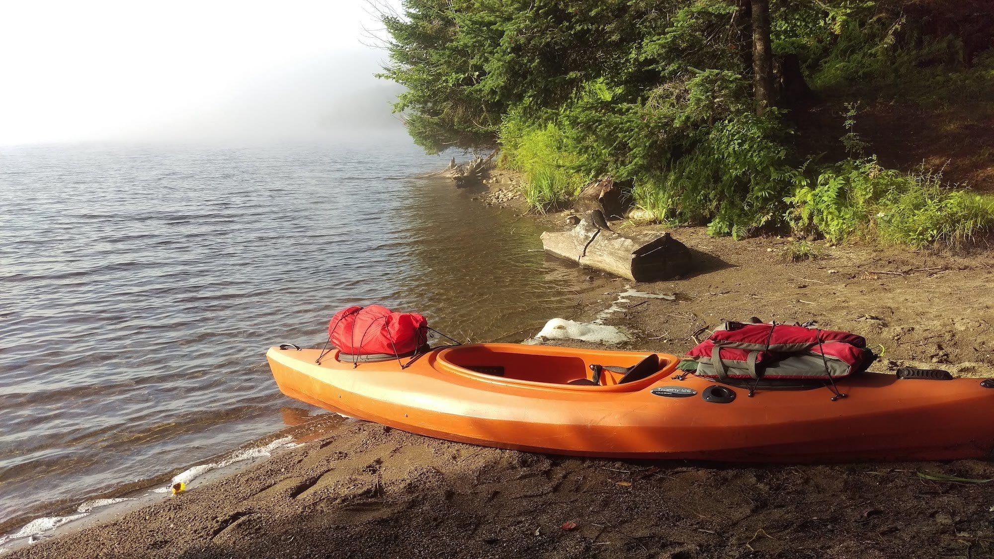 Kayak pulled onto the shore of a lake