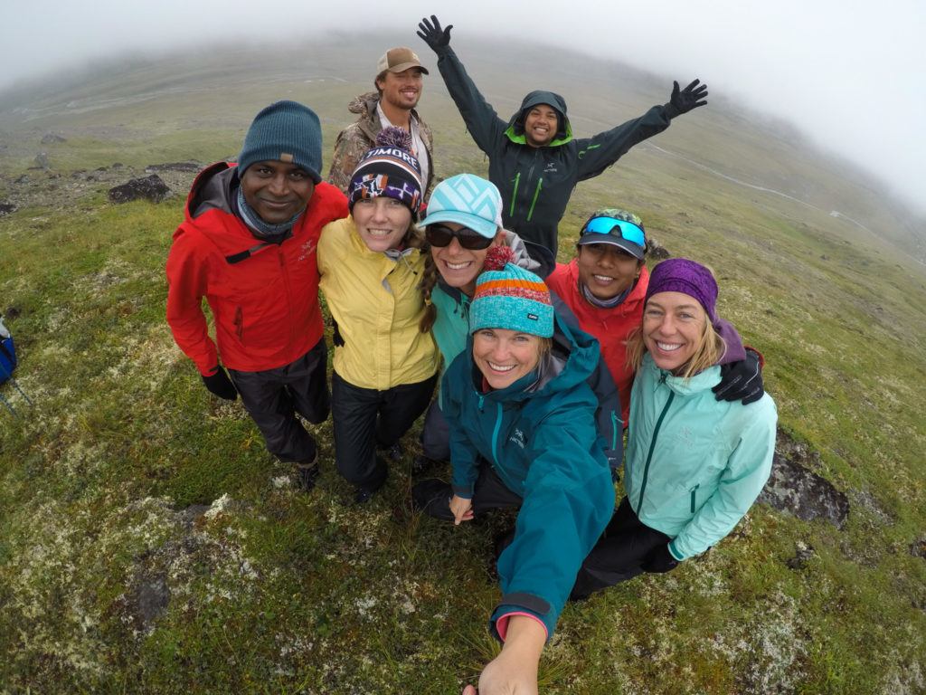 Group of hikers looking up at the camera and smiling