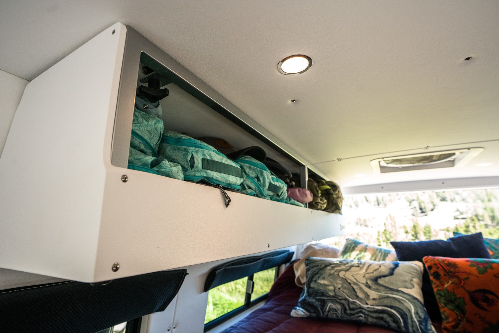 The cabinets inside a Sprinter van with REI Co-op packling cubes inside