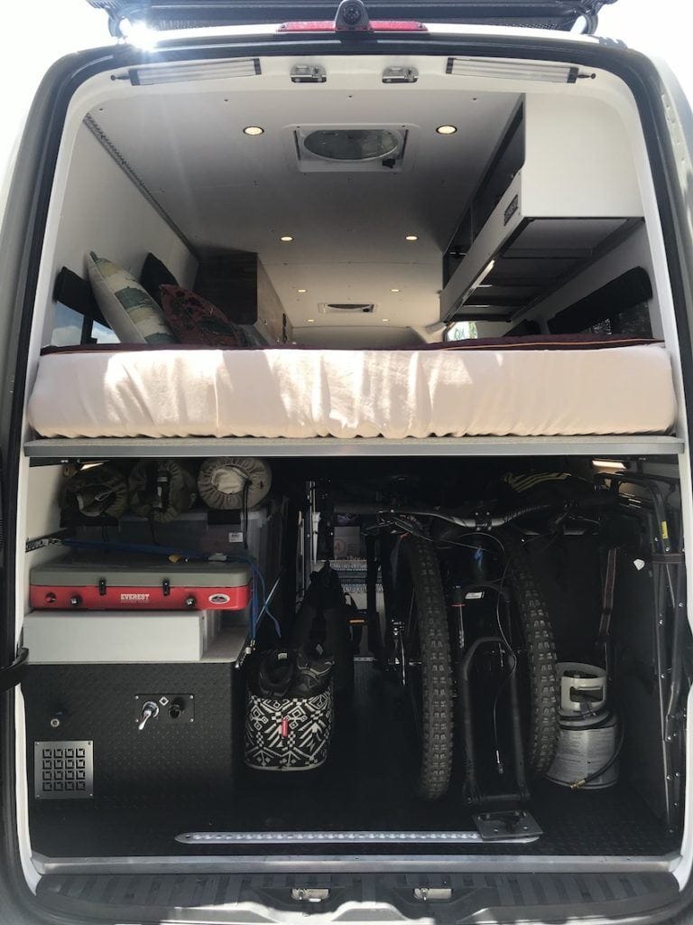 Garage area of Sprinter van filled with bikes and gear