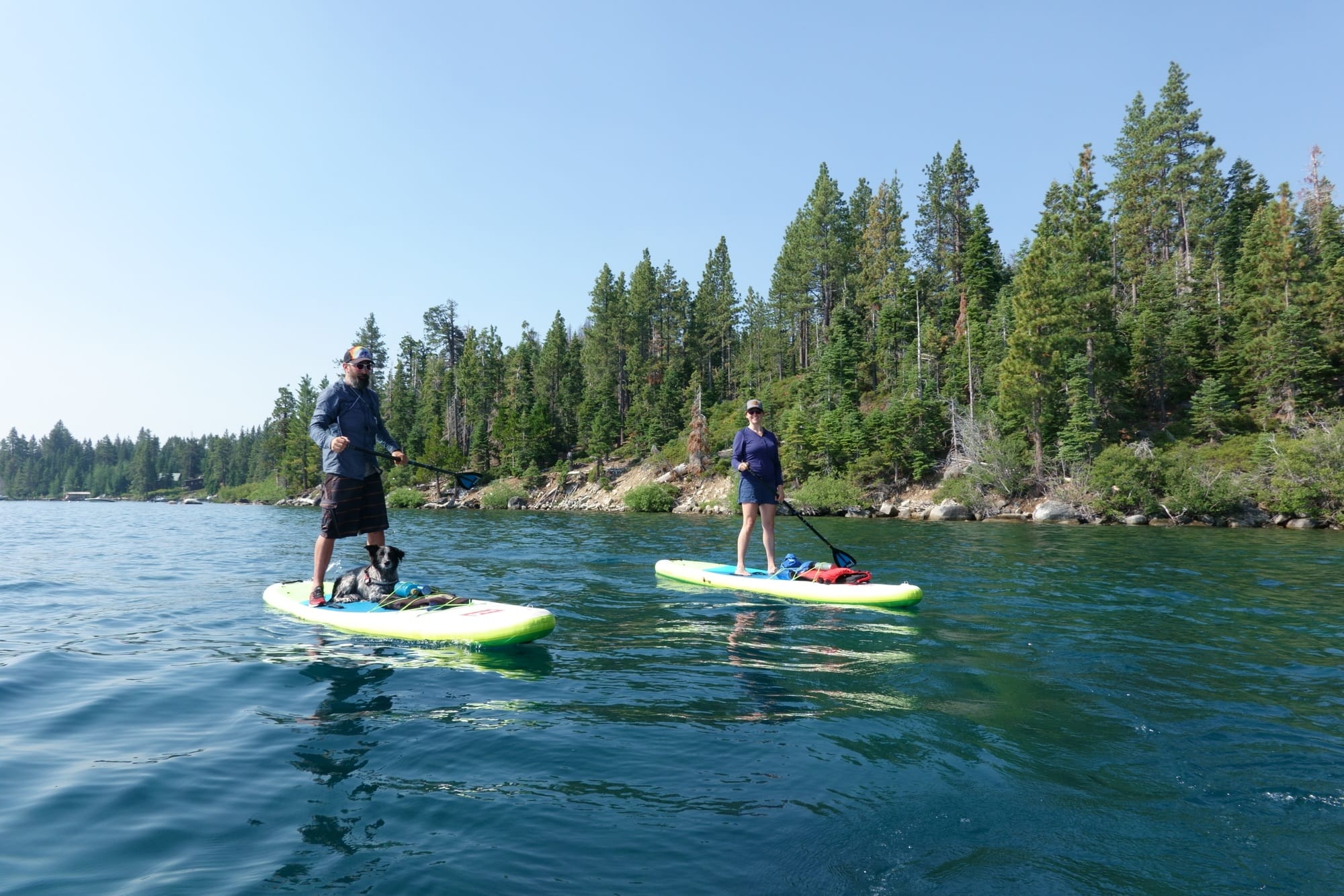 A woman and man stand-up Paddle Boarding to Emerald Bay in Lake Tahoe summer