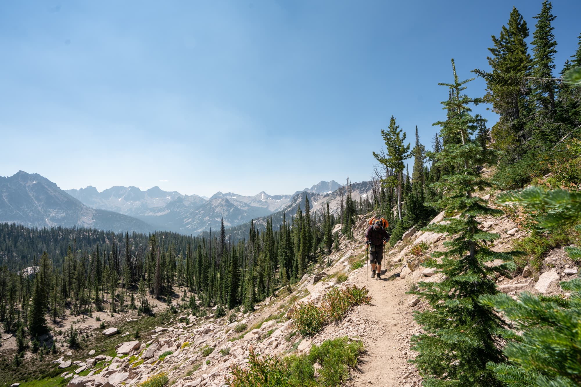 Backpacker hiking up trail in the Sawtooth Mountains wilderness of Idaho