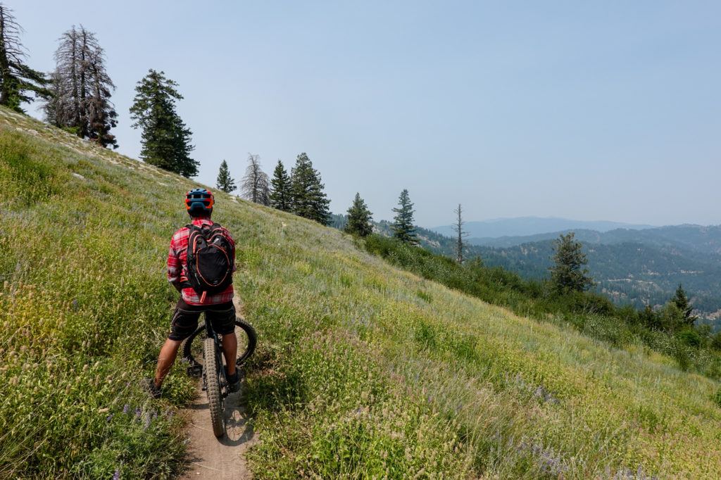 A man sits on a mountain bike at Bogus Basin near Boise Idaho on the Around the Mountain Trail