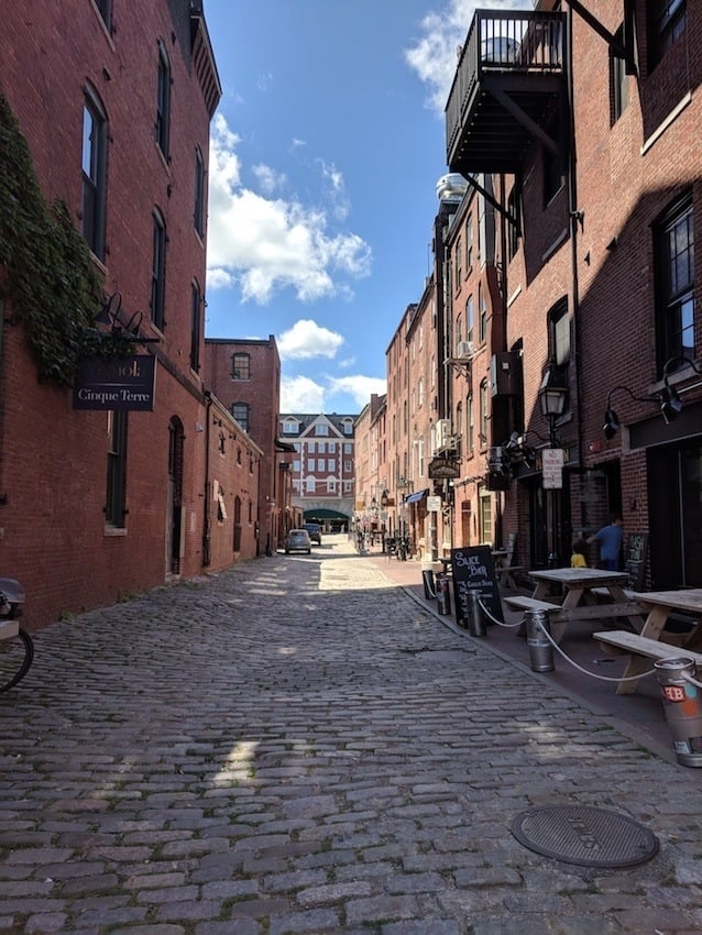 Cobblestone street lined with brick buildings in historic Old Port District of Portland Maine