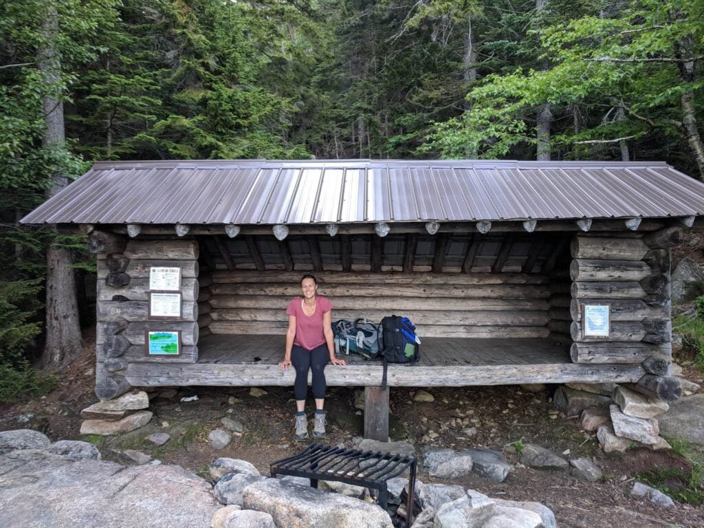 Woman sitting on the edge of a lean-to structure