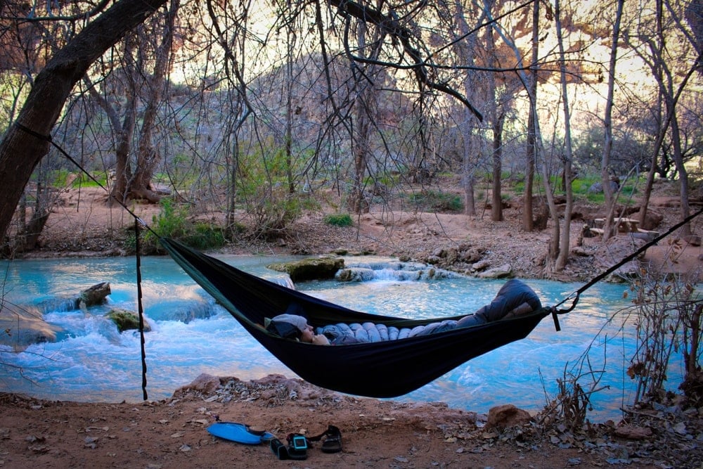 Hammock set up between two trees at Havasupai in Arizona next to blue water pool 