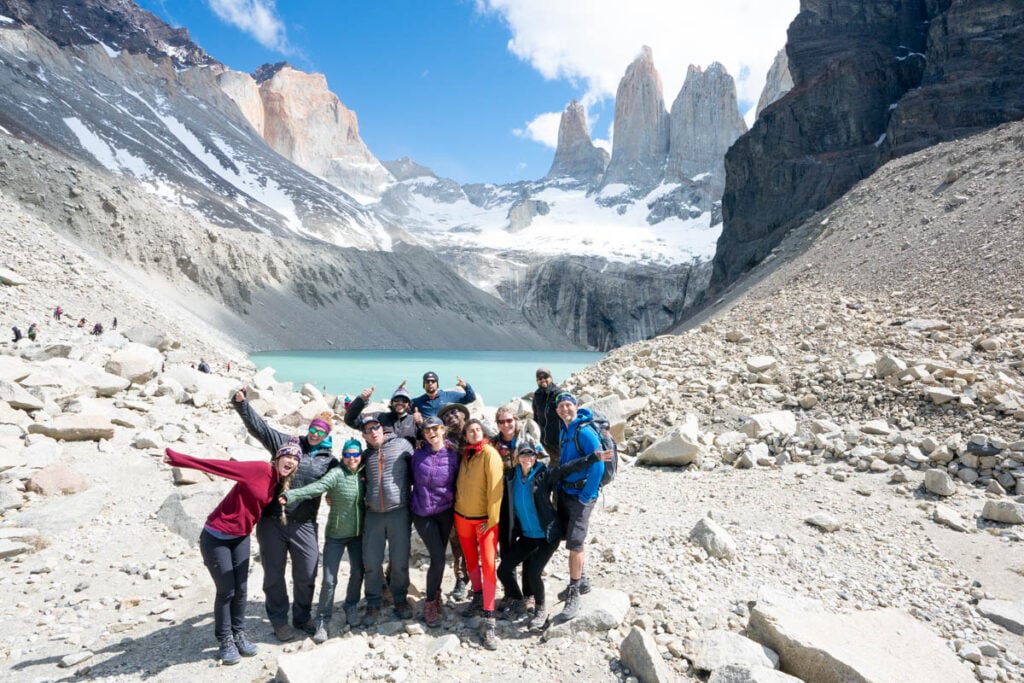 Group of people standing in front of the base of the three towers on the W Trek