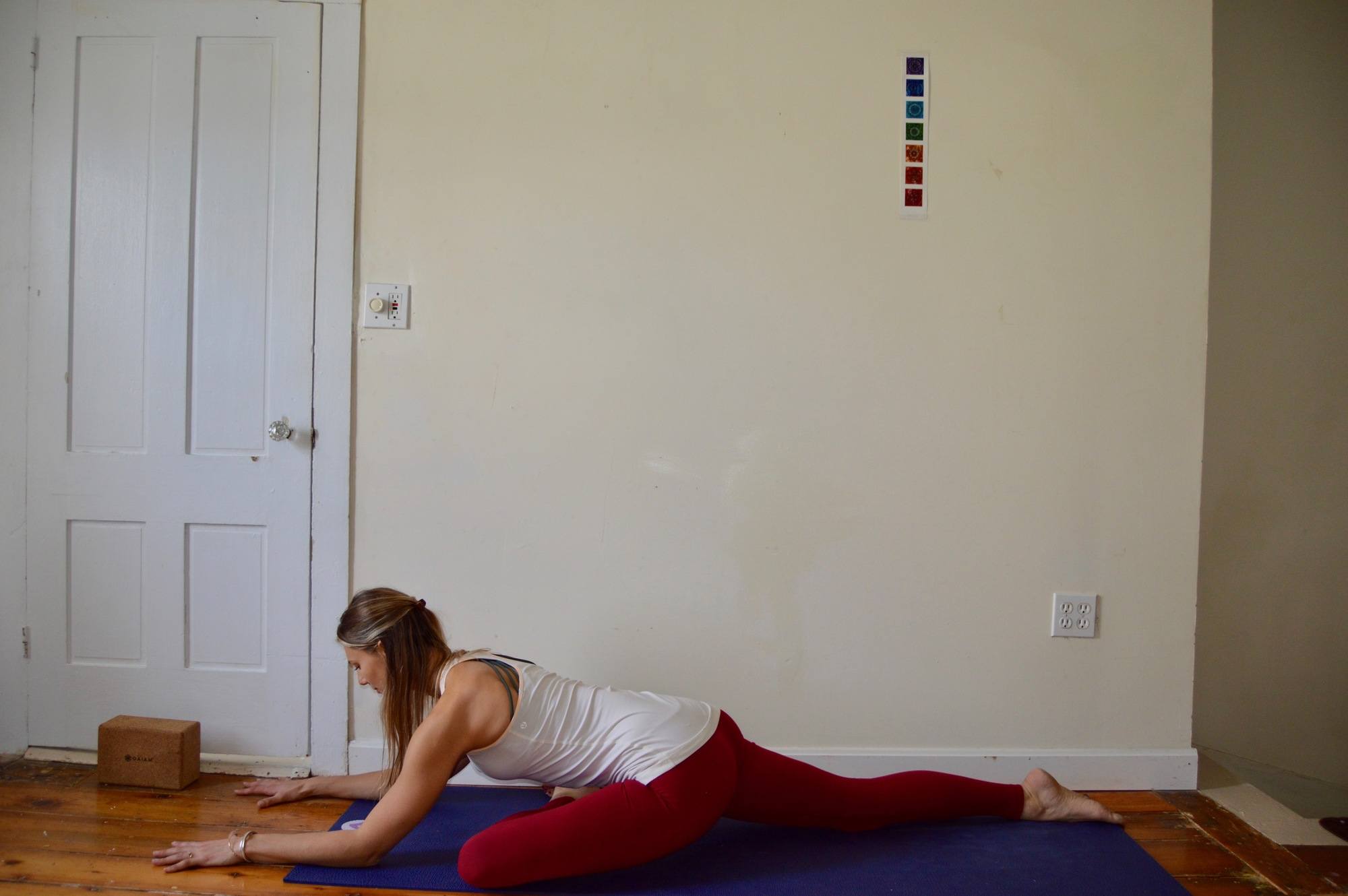 Woman holding pigeon pose on a yoga mat, demonstrating yoga for skiers