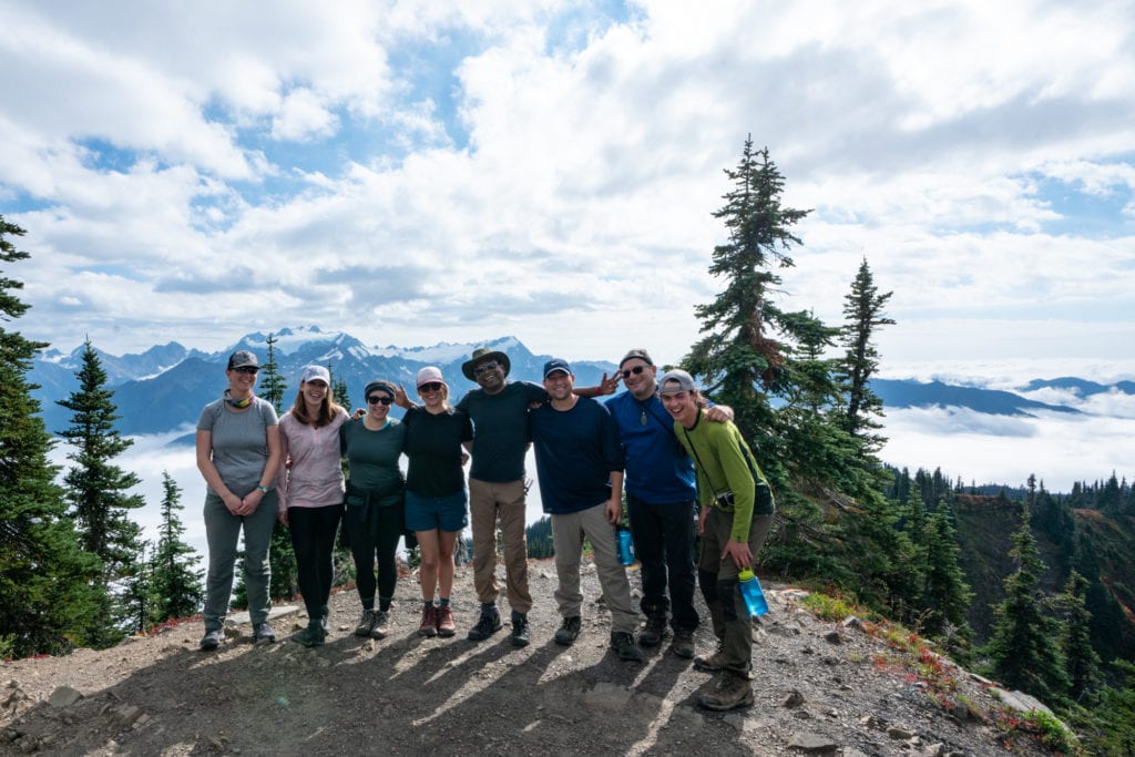 a group of hikers smiling on top of a mountain in Washington