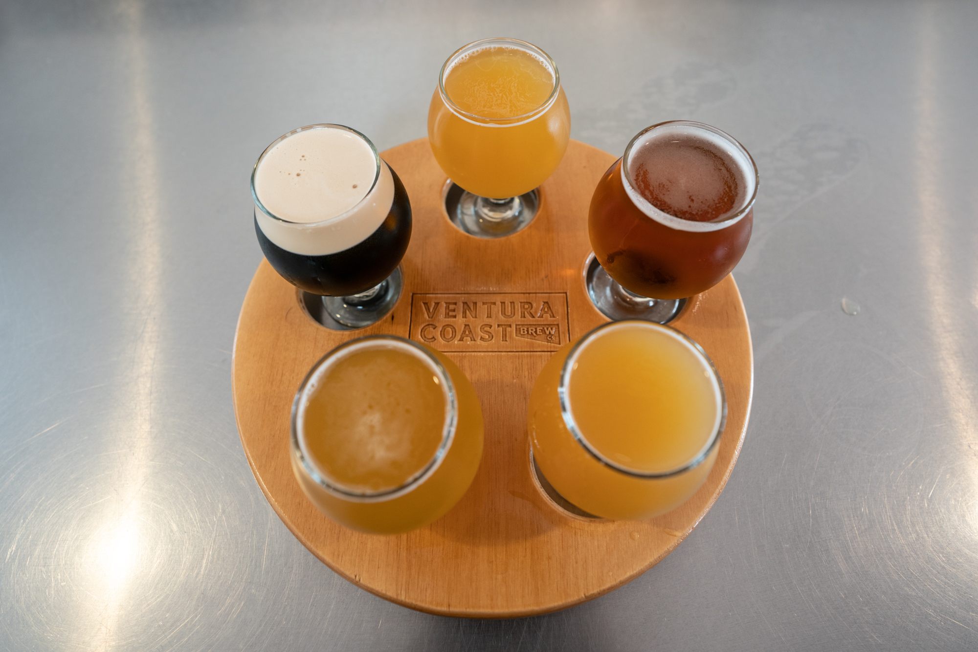 Beer tasing on a round wooden platter stamped with 