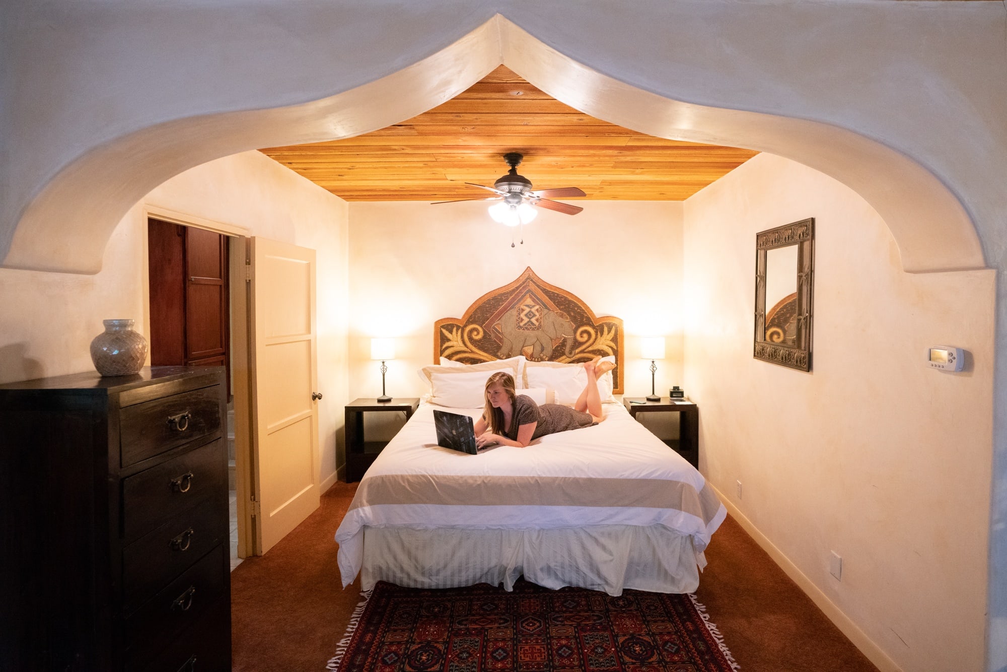 Woman lying on bed in shop hotel with southwestern decor