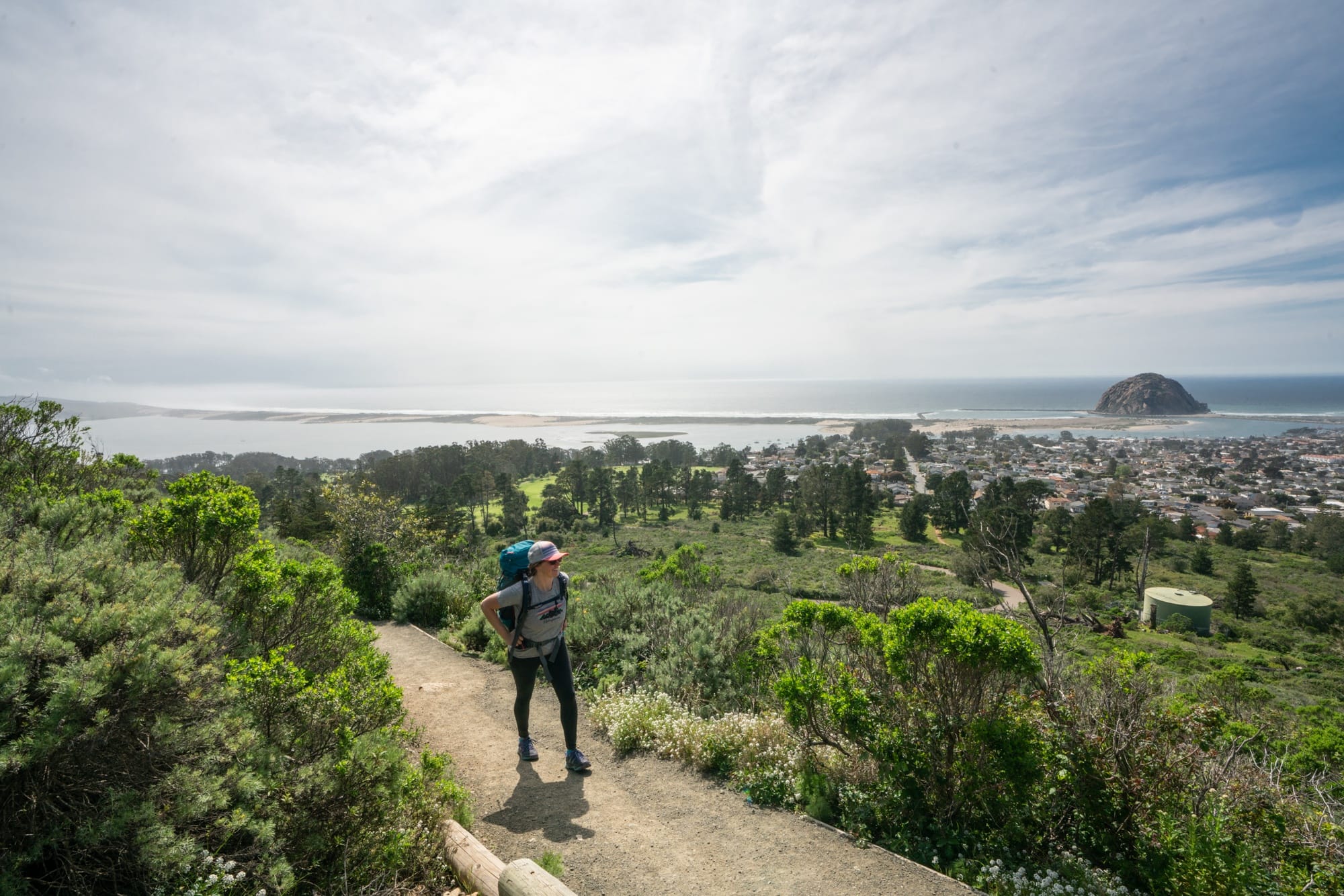 Woman hiking on trail above the ocean in Morro Bay, California