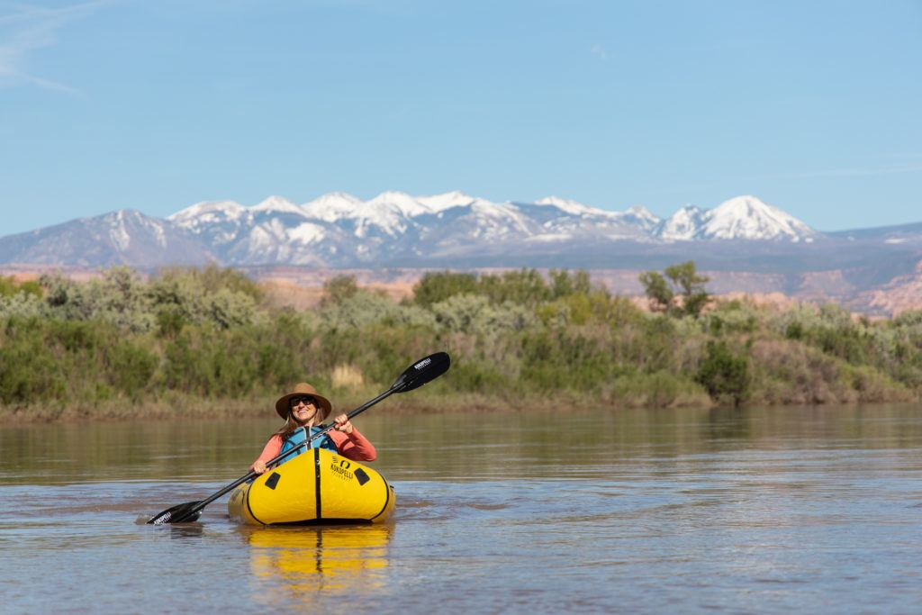 A woman sits in her Kokopelli Rogue-Lite pact raft on a river