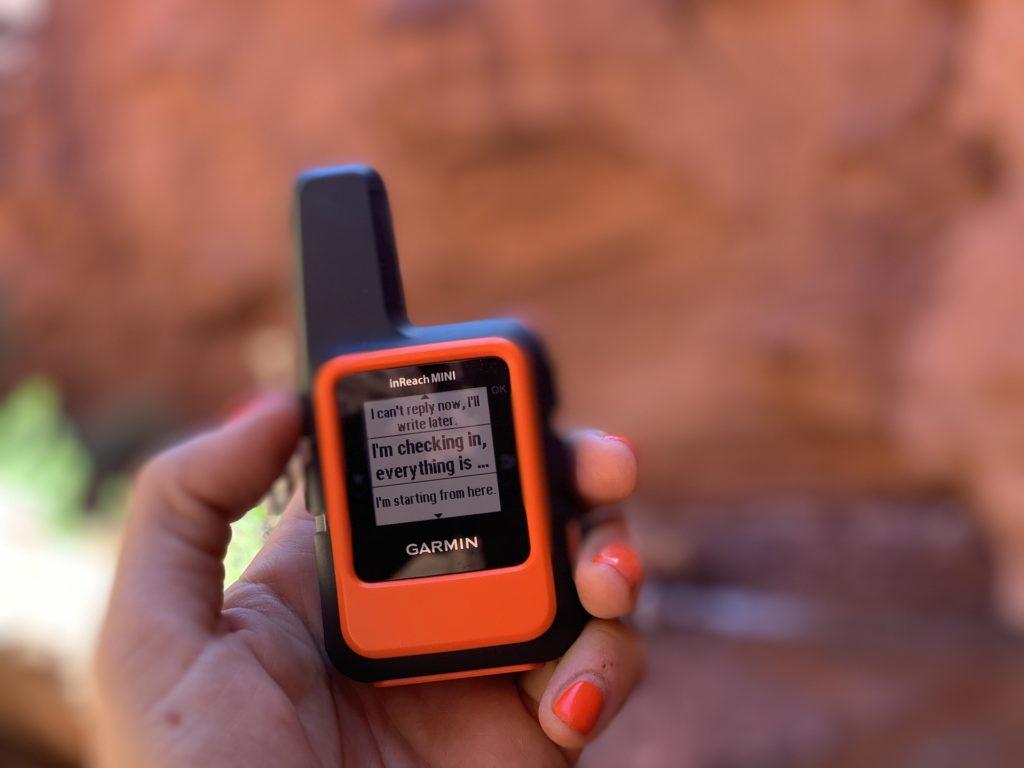 Someone holding Garmin inReach Mini communication device - an essential for every PCT gear list