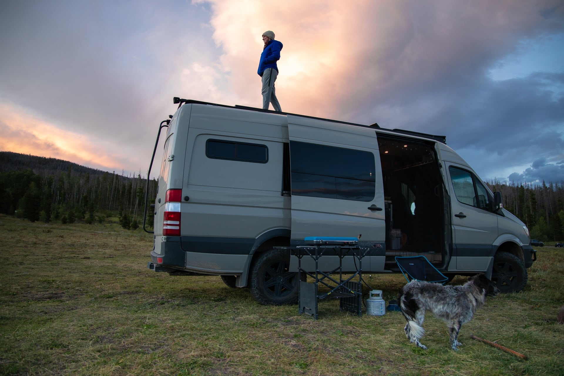 A woman stands on top of her campervan wearing Arcteryx Atom LT Hooded Jacket